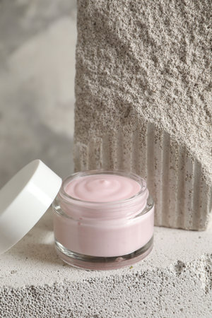 Jar of cream and lid on concrete blockの写真素材