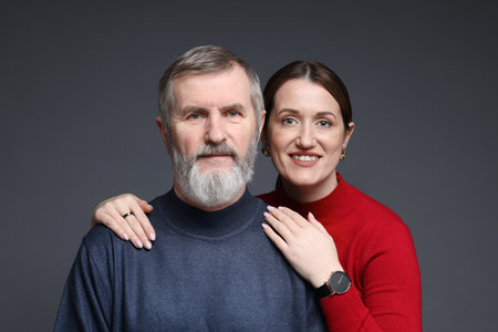 Family portrait of happy daughter and her father on dark backgroundの写真素材