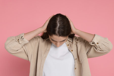 Girl with hair loss problem on pink backgroundの写真素材