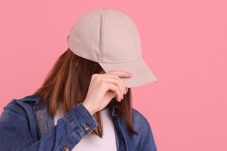 Woman in stylish baseball cap on pink background. Mockup for designの写真素材