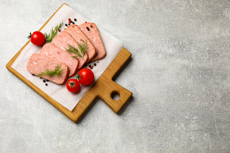 Pieces of meat, dill, peppercorns and tomatoes on grey textured table, top view. Space for text
