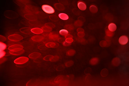 Blurred view of festive lights on red background. Bokeh effect