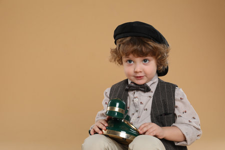 Cute little boy with old telephone on beige background, space for textの写真素材