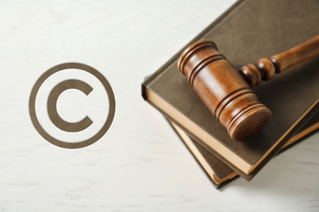 Judge's gavel with books on white wooden tableの写真素材