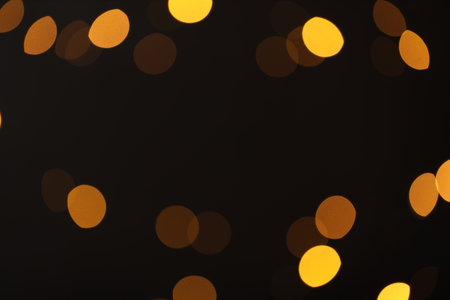 Blurred view of golden lights on black background, bokeh effectの写真素材
