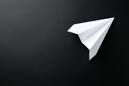 One handmade paper plane on black background, top view. Space for textの写真素材
