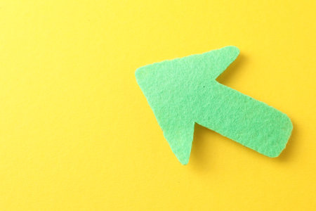 One green arrow on yellow background, top view. Space for text