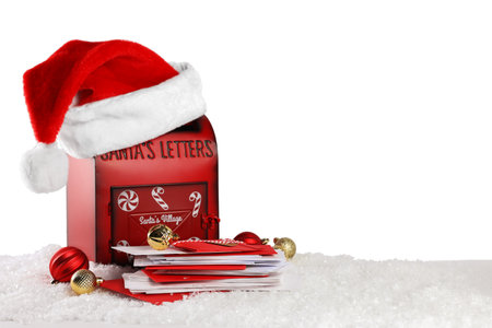 Santa Claus mail box with hat, letters and Christmas baubles on artificial snow against white background, space for textの写真素材
