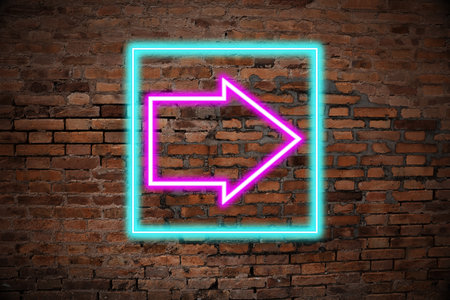 Neon pointer with arrow on brick wallの写真素材