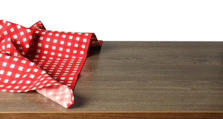 Red checkered tablecloth on wooden table against white background, closeupの写真素材