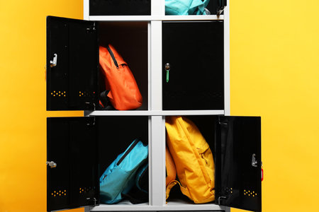 Lockers with different backpacks on orange backgroundの写真素材