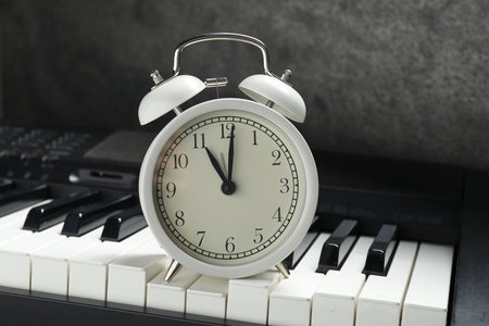 Alarm clock and electric piano on black table