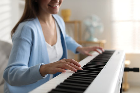 Woman playing electronic musical instrument indoors, closeup.の写真素材