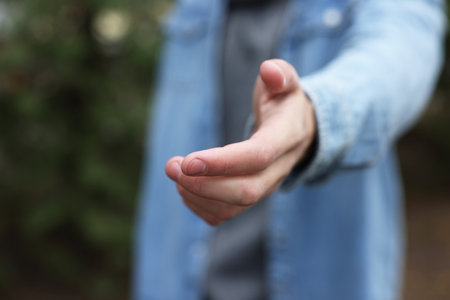 Offering help. Man reaching his hand outdoors, closeupの写真素材
