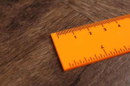 One orange ruler on wooden table, closeup. Space for textの写真素材