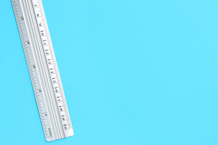 One metal ruler on light blue background, top view. Space for textの写真素材