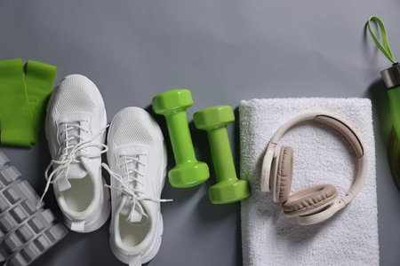 Different gym stuff and headphones on grey background, flat lay. Space for textの写真素材