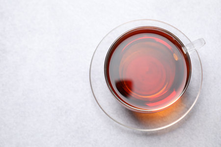 Aromatic black tea in cup on light table, top view. Space for text