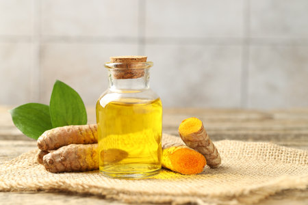 Tumeric oil and roots on table, closeupの写真素材