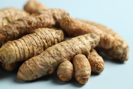 Pile of tumeric rhizomes on light blue background, closeupの写真素材