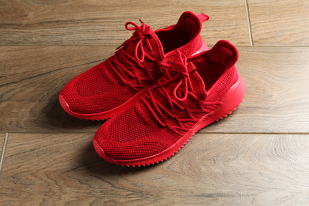 Pair of stylish red sneakers on wooden backgroundの写真素材