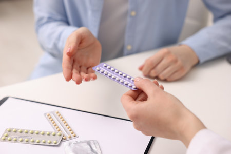 Gynecologist recommending contraceptive pills to woman in clinic, closeupの写真素材