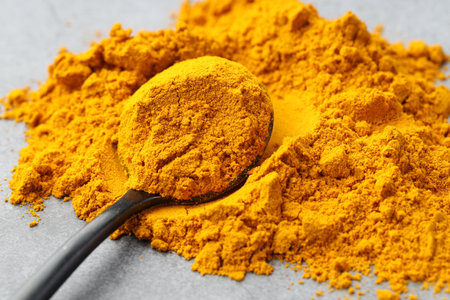 Turmeric powder and spoon on grey table, closeupの写真素材