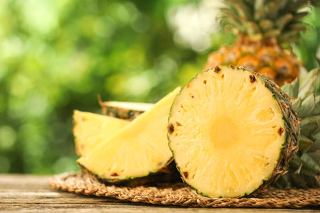 Fresh ripe pineapples on wooden table against blurred background, closeupの写真素材