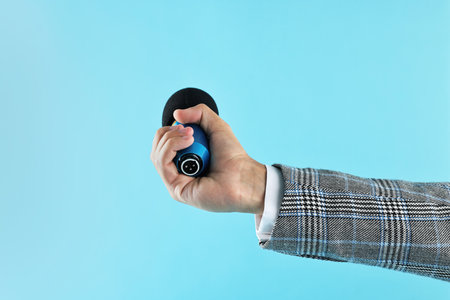 Man with microphone on light blue background, closeupの写真素材