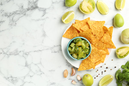 Delicious salsa with nachos on white marble table, flat lay. Space for textの写真素材