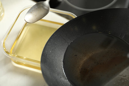 Pouring used cooking oil at white countertop, closeupの写真素材