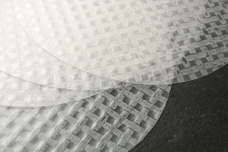 Edible rice paper sheets on dark textured table, above view