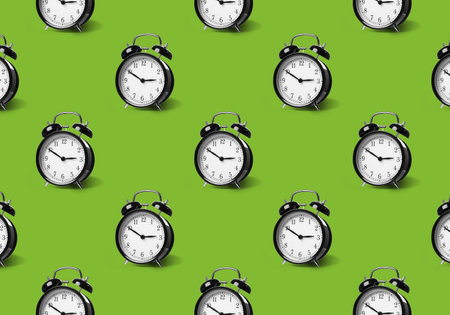Pattern of black alarm clocks on light green background