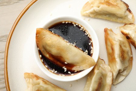 Fried gyoza dumplings with soy sauce on table, top view