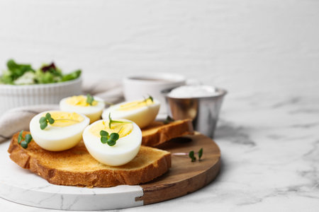 Sandwiches with hard boiled eggs on white marble table, closeup. Space for textの写真素材