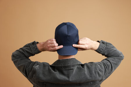 Man in stylish baseball cap on beige background, back view. Mockup for designの写真素材