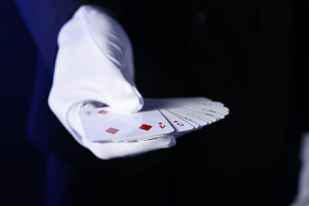 Illusionist with playing cards on dark blue background, closeupの写真素材