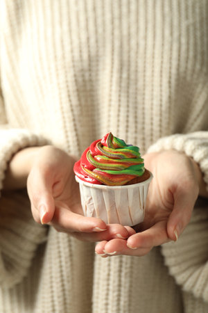 Woman holding delicious cupcake with colorful cream, closeupの写真素材