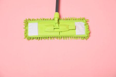 Microfiber mop on pink background, top view. space for text