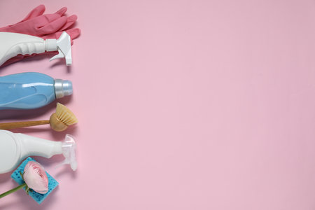 Spring cleaning. Detergents, supplies and flower on pink background, flat lay. Space for textの写真素材