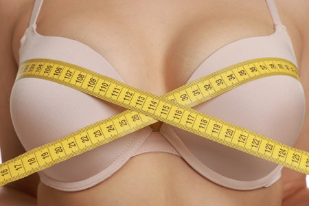 Woman in beautiful bra measuring breast circumference, closeupのeditorial素材