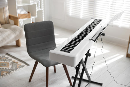 Synthesizer with music sheets and chair indoorsの写真素材