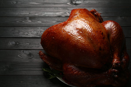 Whole baked turkey on black wooden table, closeupの写真素材