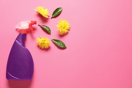 Spray bottle of cleaning product and flowers on pink background, flat lay. Space for textの写真素材
