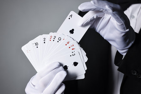Illusionist with playing cards on grey background, closeupの写真素材