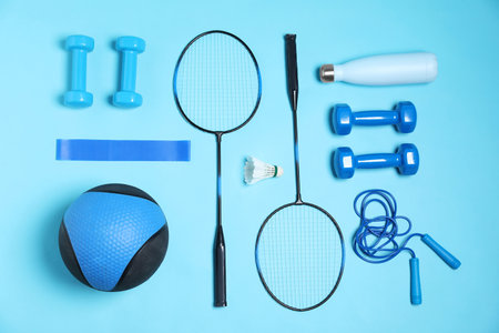 Different sports equipment and water bottle on light blue background, flat layの写真素材