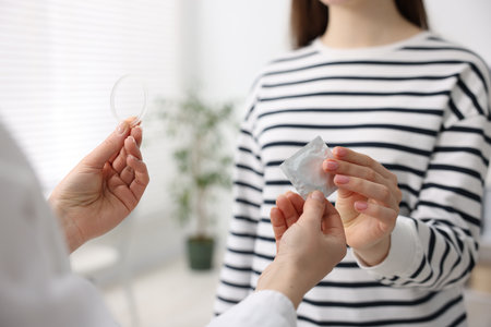 Gynecologist showing different contraceptive products to woman in clinic, closeupの写真素材