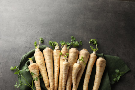 Parsley roots with leaves on black table, top view. Space for textの写真素材