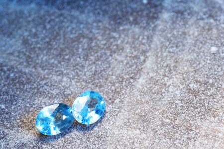 Beautiful shiny light blue gemstones on stone, space for text