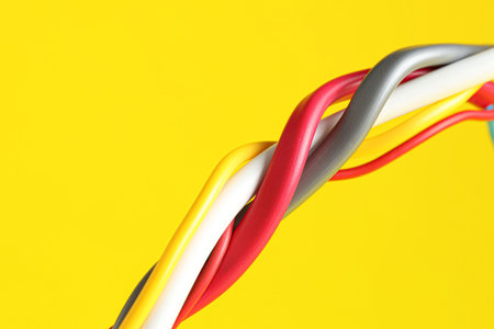 Many electrical wires on yellow background, closeup. Space for text